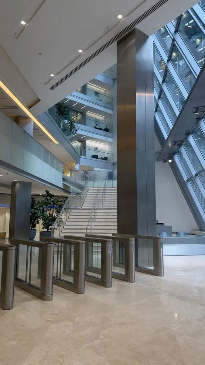 Ahli Bank atrium lobby with full-height glazed facade and glass turnstile gates