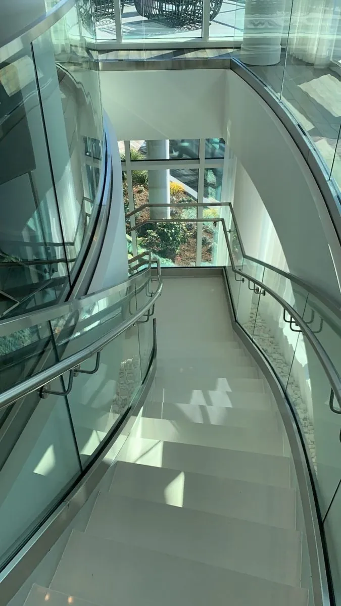 Frameless curved glass balustrade on the interior staircase at the Ahli Bank project