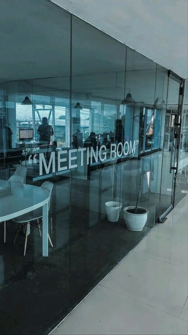 Frameless tinted glass meeting-room partition inside the Ahli Bank offices