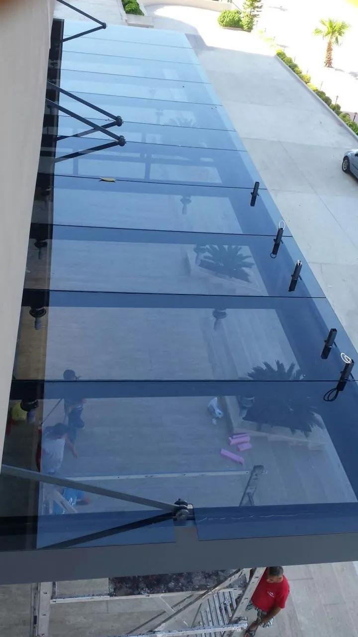 Blue solar-control glass canopy on tension-rod supports — BlueCrest, Egypt